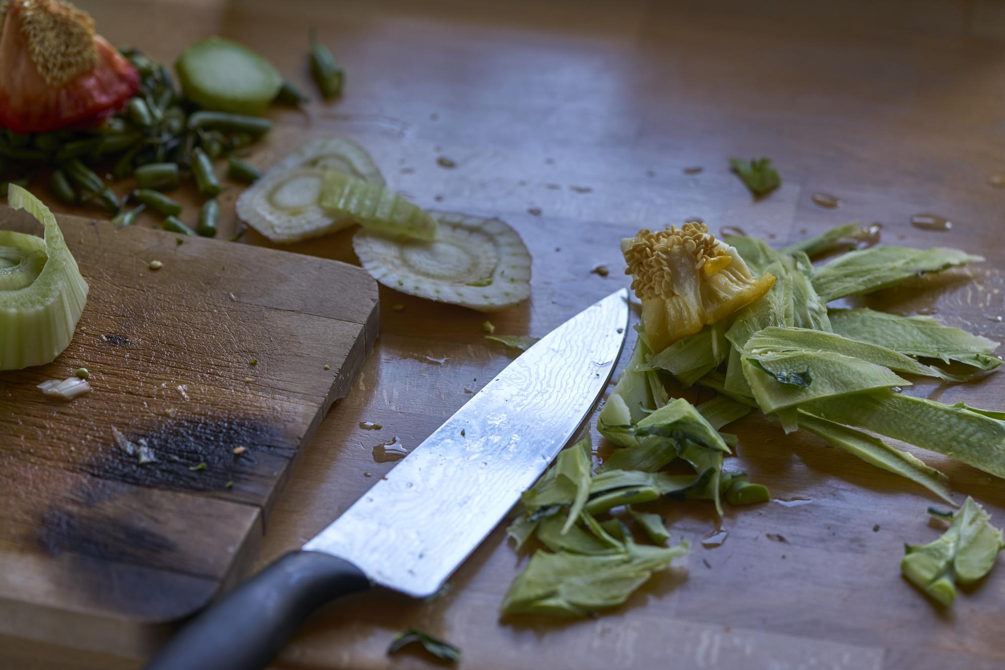 Arbeitsfläche mit Messer und frischen Kräutern